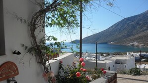 A balcony with potted plants and a view of a coastal landscape. - Froudi (Sifnos)
