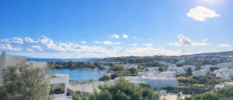A coastal town with buildings, a body of water, and a clear sky.