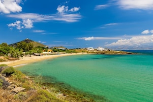 Una playa cerca, sillas reclinables de playa, sombrillas
