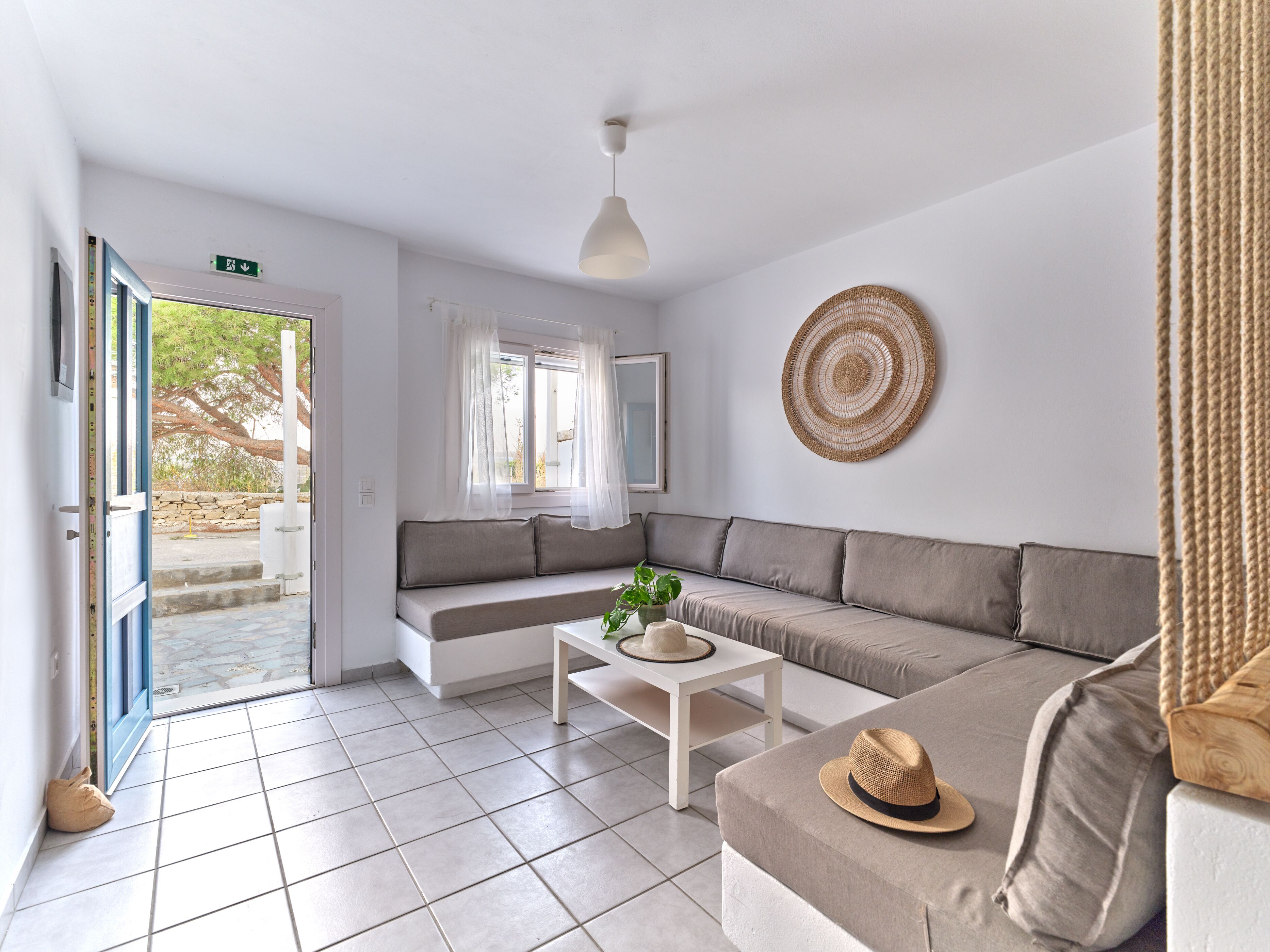 A modern living room with a sofa, a coffee table, and a hanging light fixture.