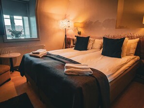 A hotel room with a bed, two bedside tables, a lamp, and a window. - Halltorps Gästgiveri (Borgholm)