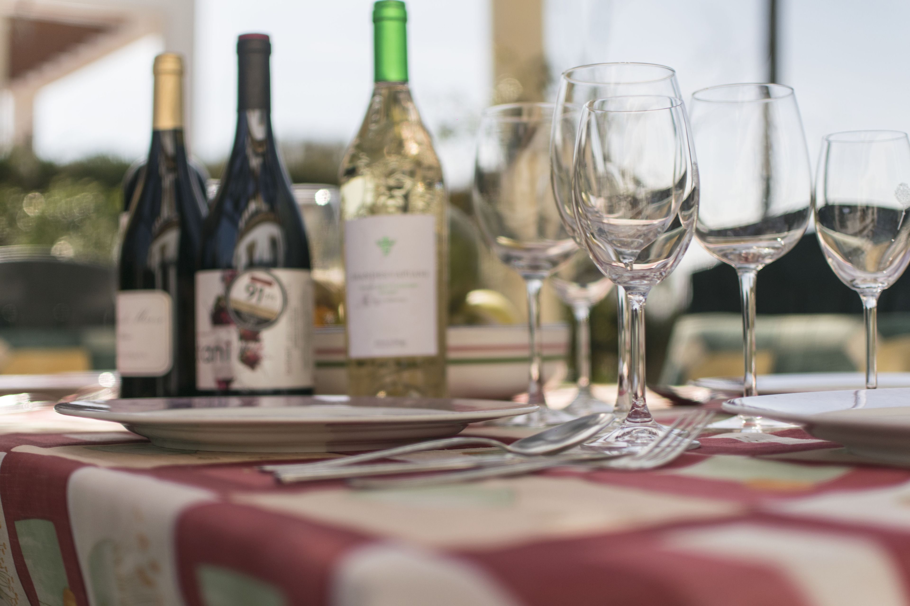 Un tavolo apparecchiato con bottiglie di vino e bicchieri, che suggerisce una zona pranzo.
