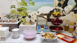 Ein reichhaltiges Frühstücksbuffet mit verschiedenen Speisen, darunter Obst, Gebäck und Getränke.