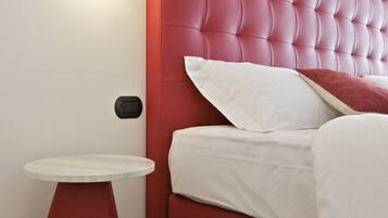 Una camera da letto moderna con una testiera imbottita rossa, un comodino rotondo e una lampada a parete.