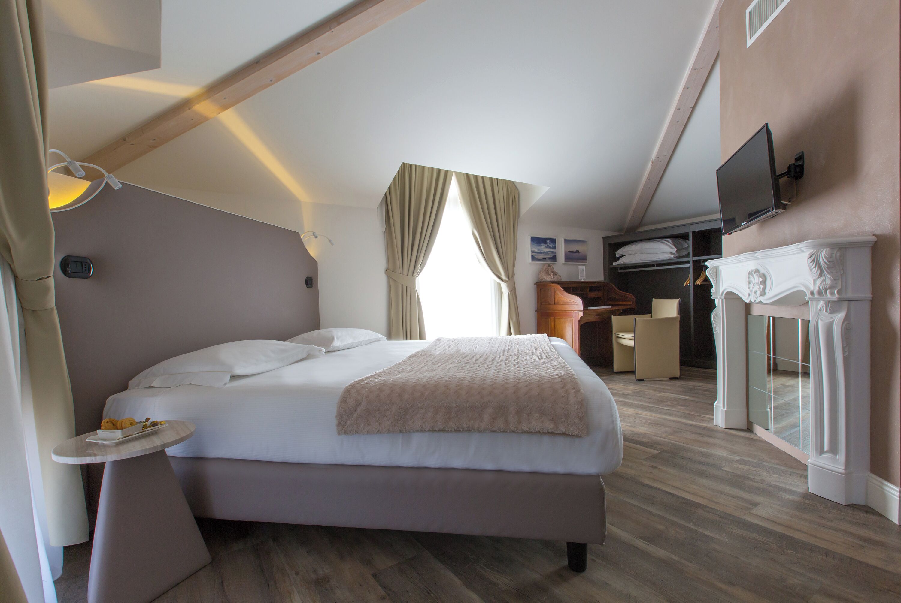 Ein Schlafzimmer mit Bett, Nachttisch und Wandfernseher.