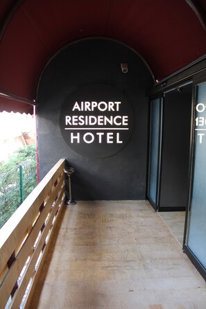 An entrance to the Airport Residence Hotel with a wooden railing and a sign on the wall. - Airport Residence Kurtkoy (Istanbul)