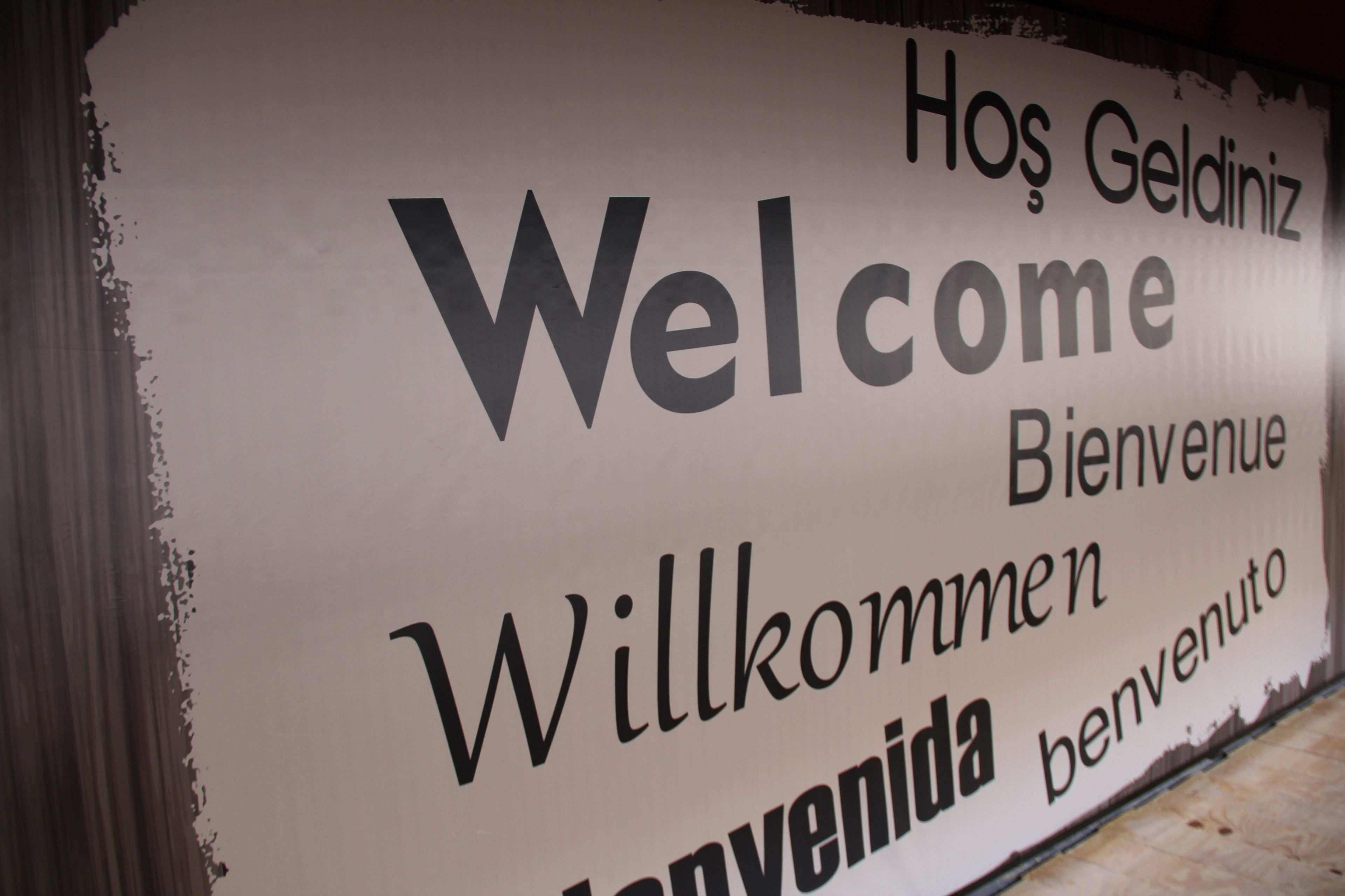 A welcome sign with multilingual greetings.