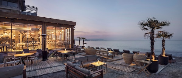 Aan een privéstrand, ligstoelen, parasols, een strandbar