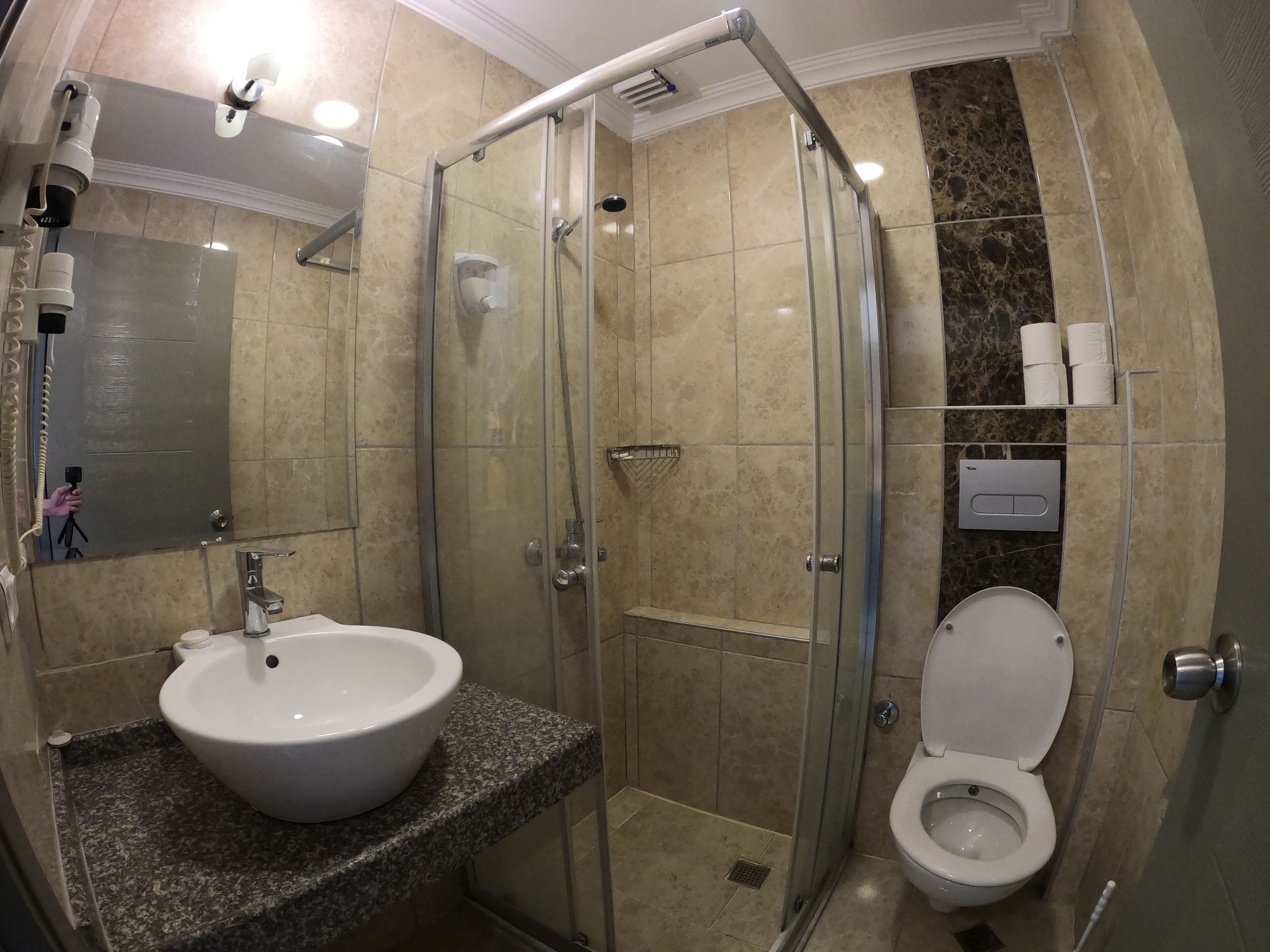 Une salle de bain avec une douche à parois de verre, un lavabo et des toilettes.