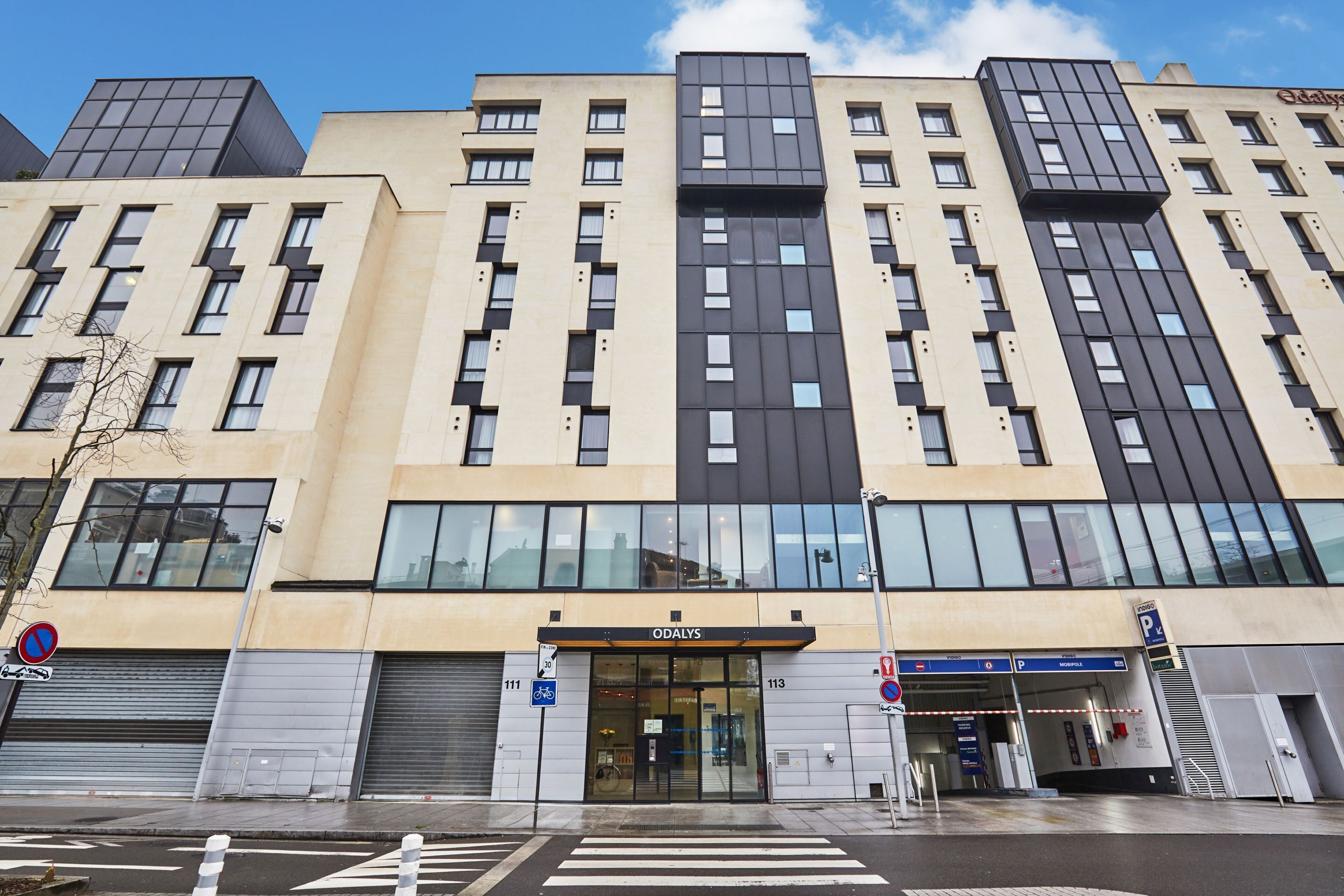 Un edificio moderno con una entrada destacada que dice "ODALYS".