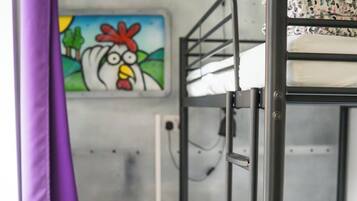 A bunk bed room with a small table and a painting on the wall.