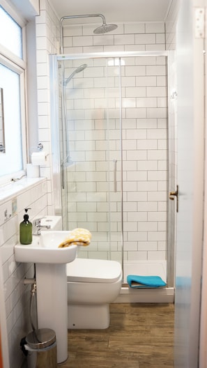 A bathroom with a shower, toilet, sink, and a window. - Igloo Hybrid - Hostel (Nottingham)
