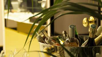 A glass container filled with various bottles, likely containing beverages, with a plant in the foreground.