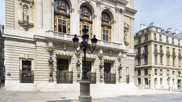 A historic building with ornate architecture, including columns, statues, and decorative windows. - Hotel Saint-Marc (Paris)