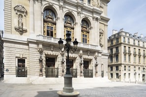 A historic building with ornate architecture, including columns, statues, and decorative windows. - Hotel Saint-Marc (Paris)