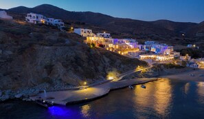 A coastal village with white buildings, a paved road, and boats on the water. - Blue Sand Boutique Hotel & Suites (Folegandros)