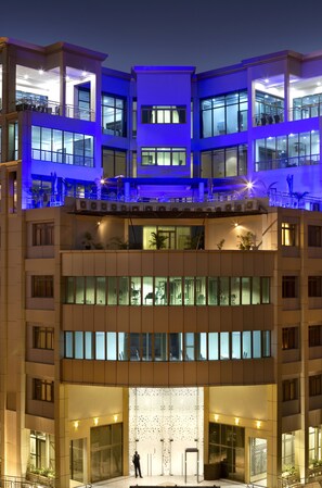 A multi-story hotel with a modern design, featuring balconies, large windows, and a central atrium.