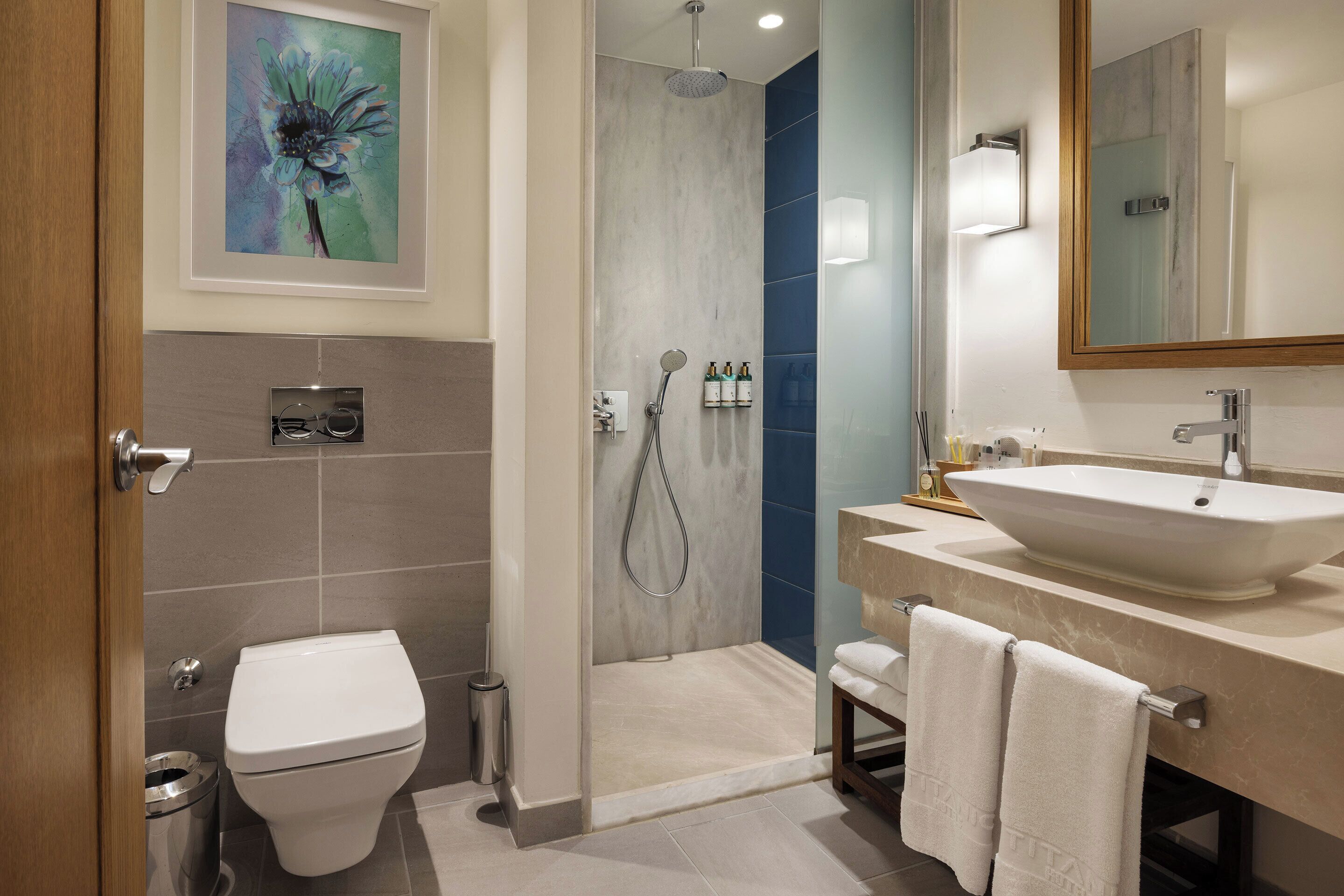 Une salle de bain moderne équipée d’une douche, de toilettes et d’un lavabo.