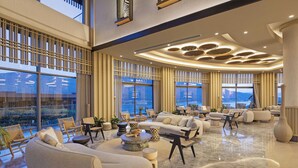 A spacious living area with a modern design, featuring a large sofa, armchairs, and a coffee table. - Titanic Luxury Collection Bodrum - All inclusive (Milas)