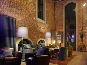 Relax in a spacious lounge area with leather armchairs, sofas, and a central coffee table.