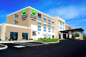 A Holiday Inn Express & Suites hotel with a modern design, featuring a parking lot and a covered entrance. - Holiday Inn Express & Suites Oswego by IHG (Oswego)