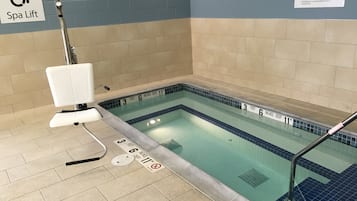 Een spa-lift in een zwembadgedeelte met dieptemarkeringen en een bordje met de tekst Spa Lift.