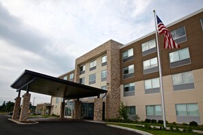 A multi-story building with a covered entrance and an American flag.