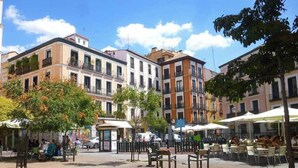 A public square with outdoor seating, surrounded by multi-story buildings with balconies. - Apartment in Malasaña   (Madrid)