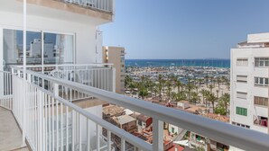 Un balcon avec vue sur un port de plaisance et une plage.