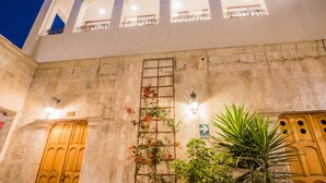 Un edificio de fachada de piedra, una puerta de madera y un cartel que indica la salida.