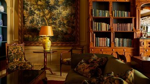 A traditional library with a large painting, a wooden bookshelf, and classic furniture. - Batty Langley's (London)