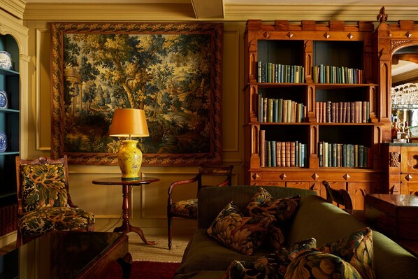 A traditional library with a large painting, a wooden bookshelf, and classic furniture. - Batty Langley's (London)