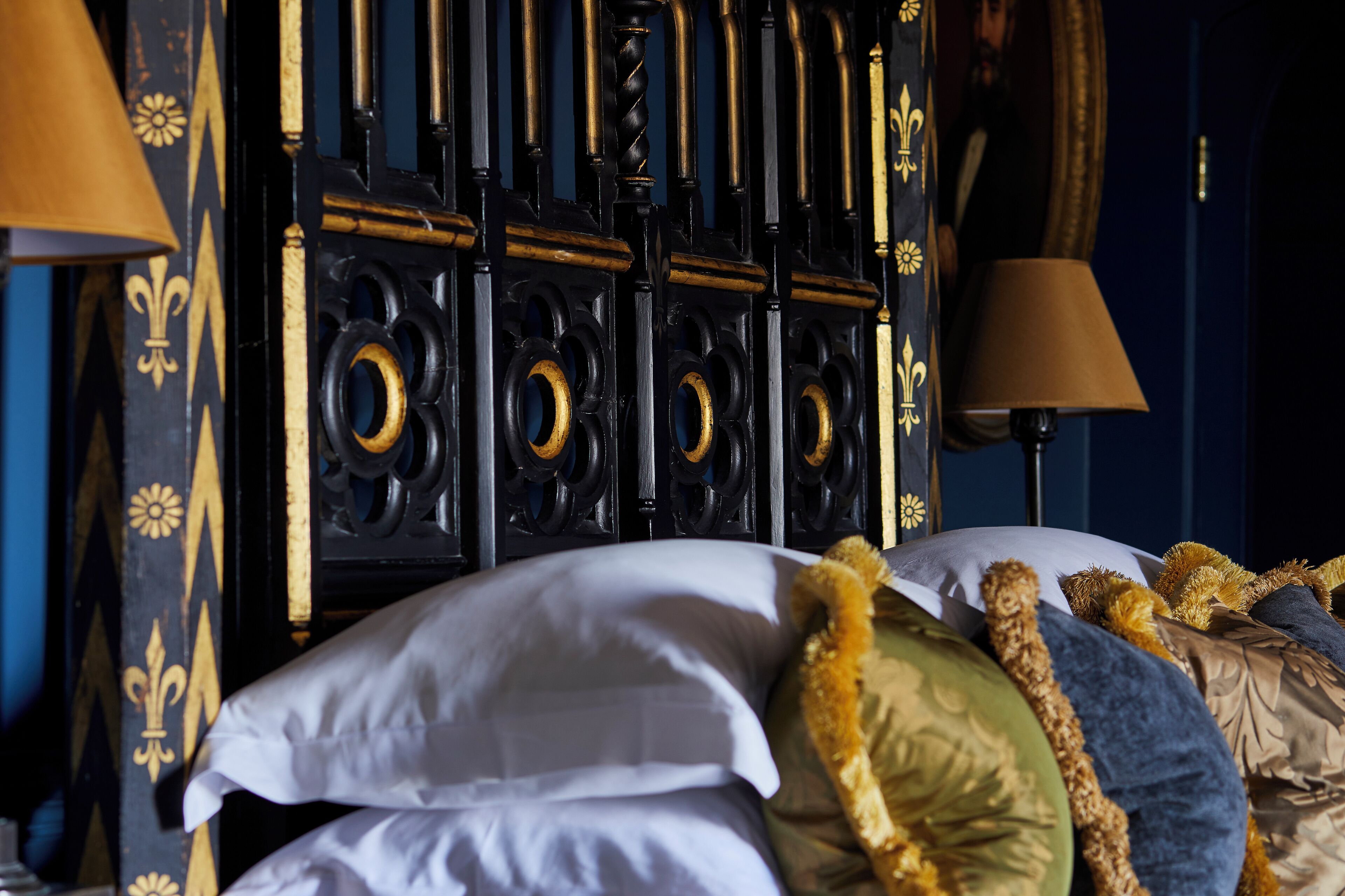 A bed with multiple pillows and a decorative headboard.