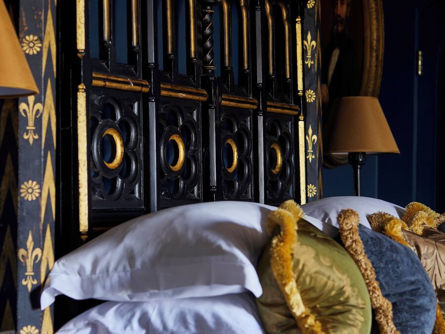 A bed with multiple pillows and a decorative headboard.