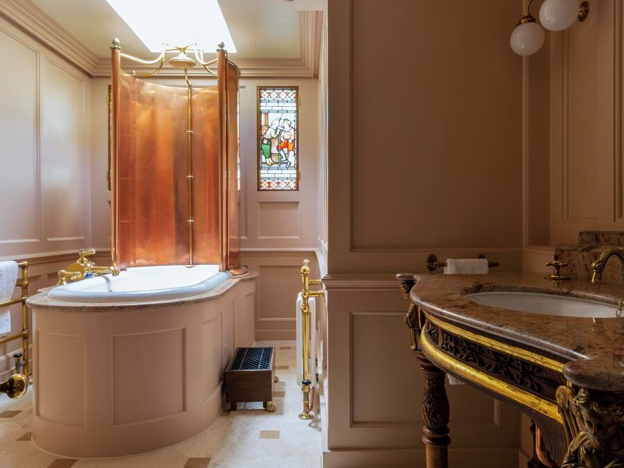 Ein luxuriöses Badezimmer mit einer großen Badewanne, einem separaten Waschbecken und einem dekorativen Duschvorhang.