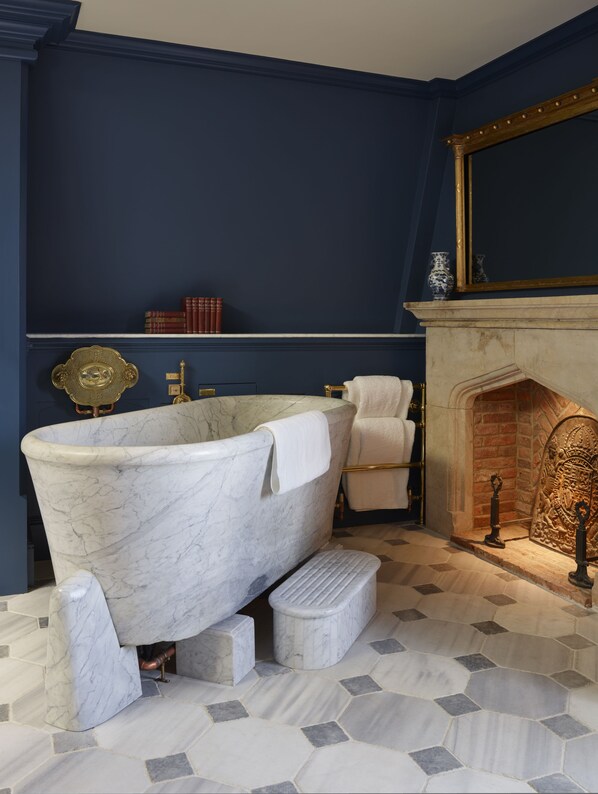 A bathroom with a freestanding bathtub, a marble floor, and a fireplace. - Batty Langley's (London)