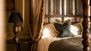 A bedroom with a four-poster bed, a lamp, and a painting on the wall. - Batty Langley's (London)