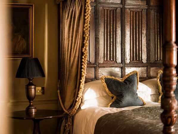 A bedroom with a four-poster bed, a lamp, and a painting on the wall. - Batty Langley's (London)