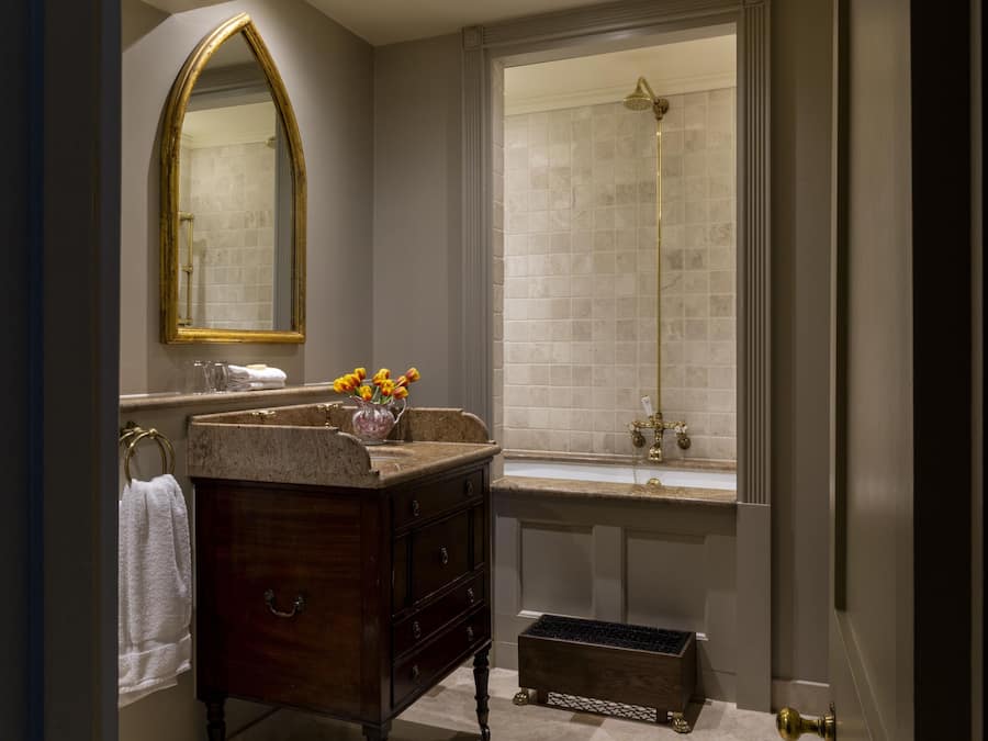 A bathroom with a vanity, a mirror, a shower, and a window.