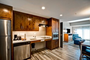 A compact kitchen with wooden cabinets, stainless steel appliances, and a modern design.