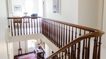 A multi-level staircase with wooden railings and a chandelier.