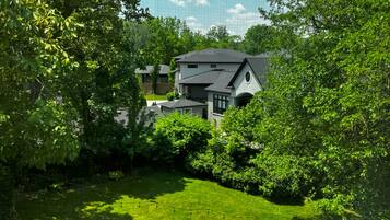 A large house surrounded by lush greenery and a well-maintained lawn.