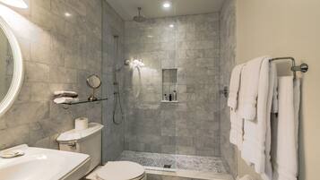 A modern bathroom with a shower, toilet, and sink.