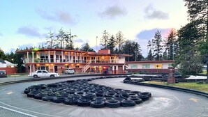 A building with a parking lot filled with tires, surrounded by a fence. - Breakers Boutique Inn (Westport)