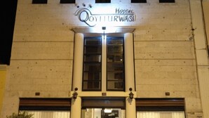 Um edifício com uma placa que diz "Qoyiturwasi Hostel" à noite.