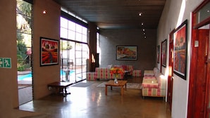 A spacious lobby with a pool view, comfortable seating, and artwork on the walls.