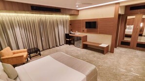 Una habitación de hotel con una cama grande, un escritorio, una silla y un sofá.