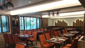Un restaurante con varias mesas y sillas, amplias ventanas y un diseño interior moderno.