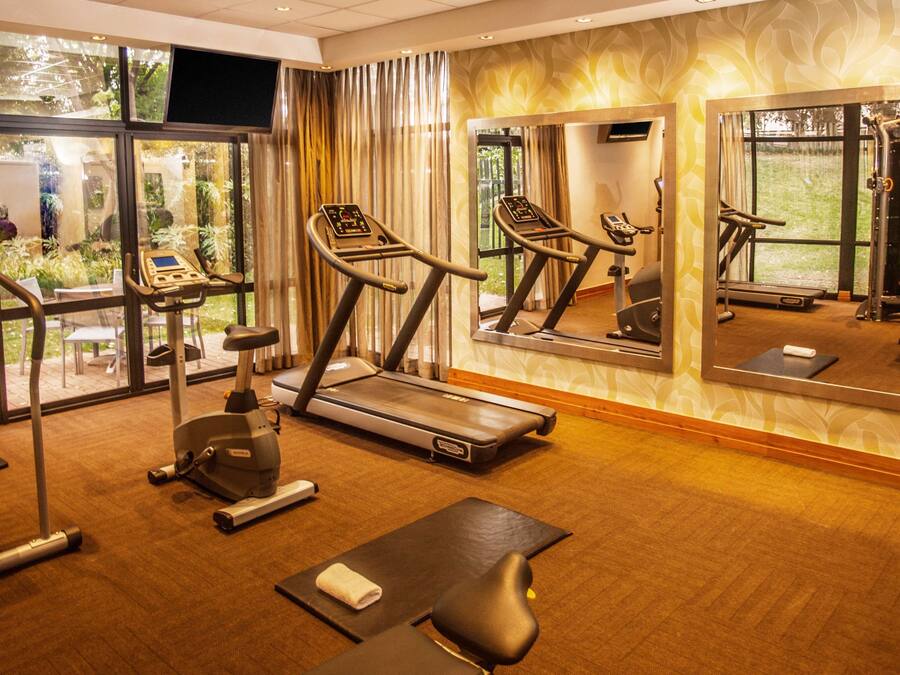 A gym with treadmills, an elliptical, and a rowing machine.