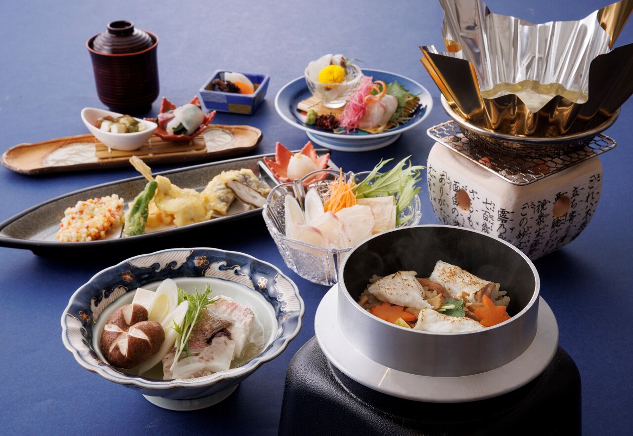 A variety of Japanese dishes arranged on a table, including sushi, sashimi, and other seafood items.